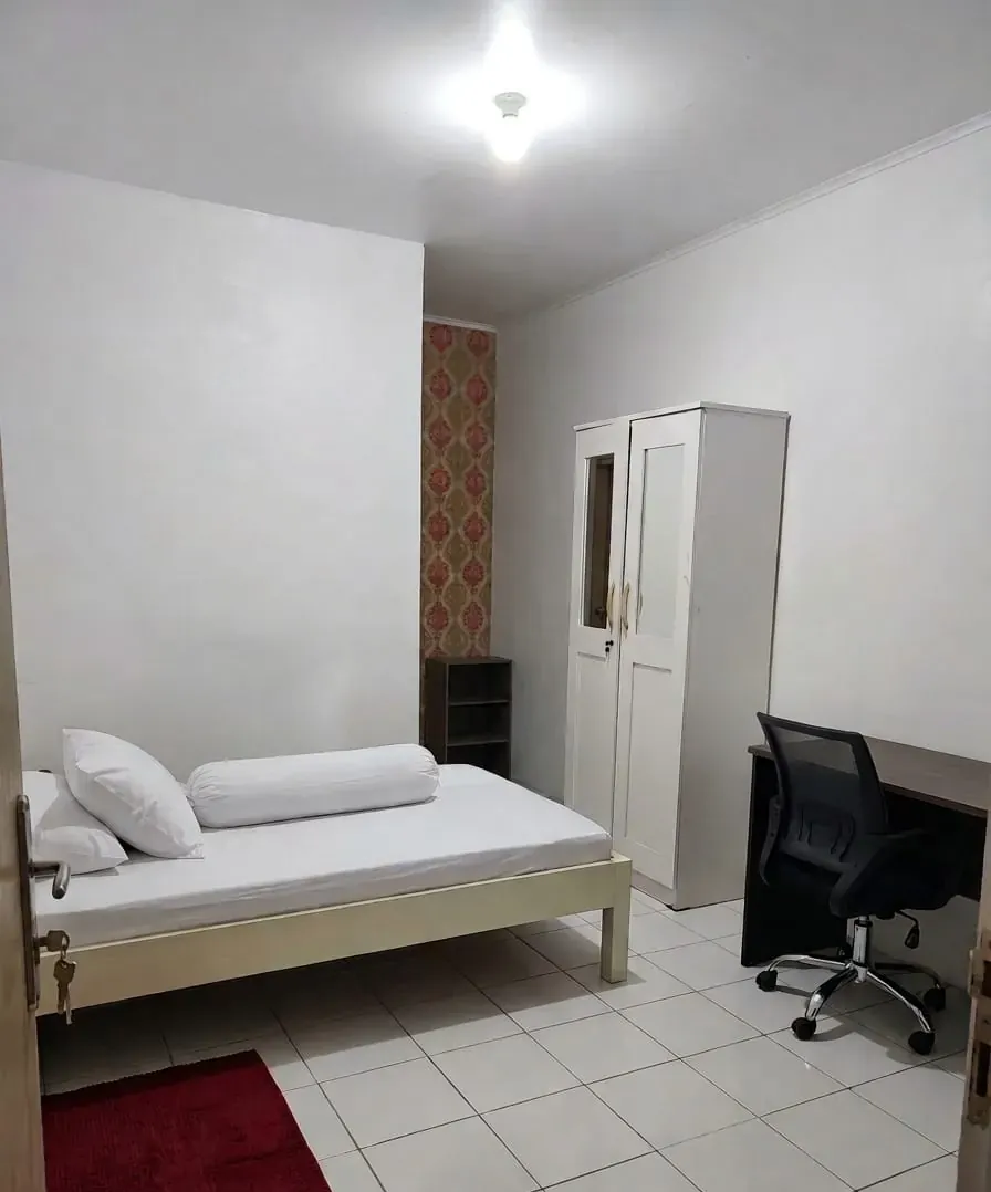 Kamar asli Kost Rasya dengan tempat tidur dan meja